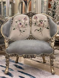 an ornately decorated chair sits in front of a mirror