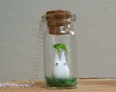 a glass bottle with a bunny in it sitting on top of a piece of wood