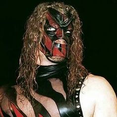 a man with long hair wearing a wrestling mask