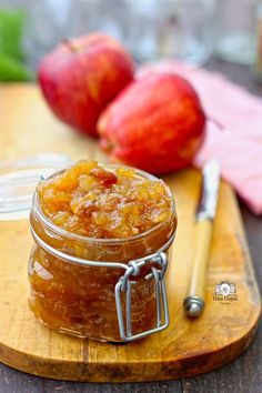 an apple jam in a glass jar on a cutting board