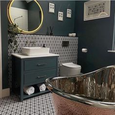 a bath tub sitting next to a toilet in a bathroom under a mirror and sink