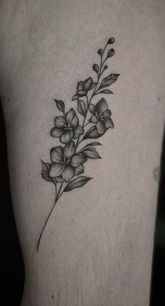 a black and white flower tattoo on the thigh