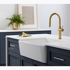 a white sink sitting under a faucet next to a window in a bathroom