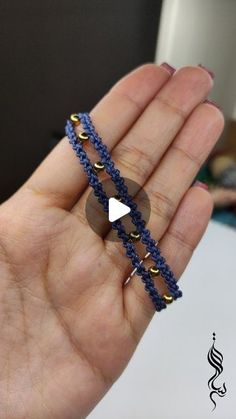 a hand holding a beaded bracelet with an arrow on it