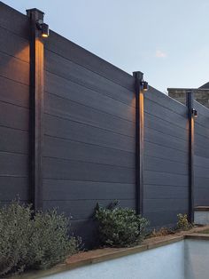 an outdoor swimming pool next to a tall building with lights on it's sides