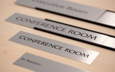 three metal name tags sitting on top of a wooden table