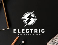 an electric logo with pencils and ink on a black table next to some other items