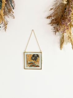 a painting hanging on a wall next to dried flowers