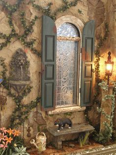 a window with green shutters next to a bench and potted plant in front of it