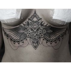 the back of a woman's body with an intricate tattoo design on her stomach