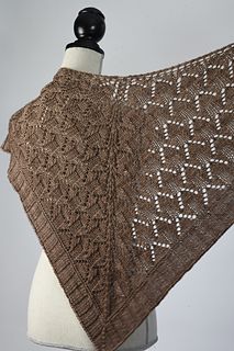 a brown knitted shawl on a white mannequin headdress,