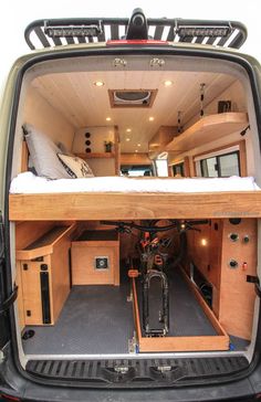 the back end of a van with a bike in it's cargo area and storage compartment