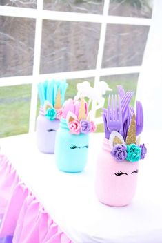 there are three little cups with unicorns on them sitting on top of a table