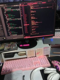 two computer monitors sitting on top of a desk next to a keyboard and headphones