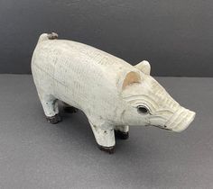 a white ceramic animal figurine on a gray surface