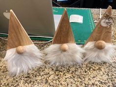 three wooden gnome hats sitting on top of a counter next to an apple computer keyboard