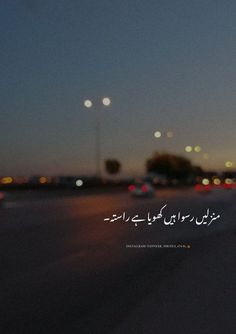 a blurry photo of cars driving down the road at night with arabic writing on it