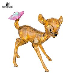 a golden dog figurine with a pink hat on it's head and tail