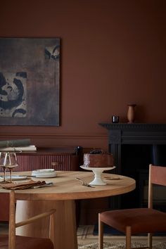 a table and chairs in a room with a painting on the wall behind it,