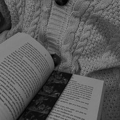 an open book sitting on top of a bed next to a stuffed animal and blanket