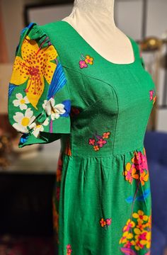 This is such a fantastic dress. Its green with Bright colors of Pink, Orange, Blue, Yellow and brown. The sleeves have a bit of puff to them with an elastic near the bottom of the sleeve. Its a maxi. There is a back nylon zipper and an eyehook closure at back. I see no tags. The material looks like a cotton mix. Its in fantastic condition. Please see measurements to ensure a proper fit. Bust: 33" Waist: 28" Length: 56" This item is pre-loved, as is. Thanx for checking out my shop. Have an awesom Fitted Green Vintage Dress With Floral Print, Fitted Green Floral Vintage Dress, Green Floral Print Vintage Dress, Green Retro Vintage Dress, Vintage Fitted Green Dress, 1970s Style Green Summer Dresses, Green Fitted Vintage Dress, Green Vintage Style Dress For Summer, Green Vintage Dress For Summer