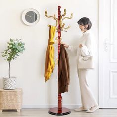 a woman standing next to a coat rack