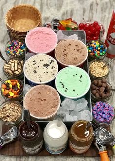 an ice cream sundae board with many different flavors and toppings in bowls on it