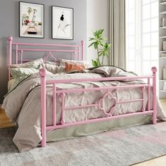 a pink metal bed frame in a bedroom with bookshelves and pictures on the wall