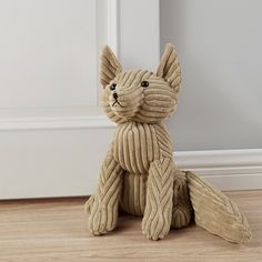 a knitted cat sitting on the floor