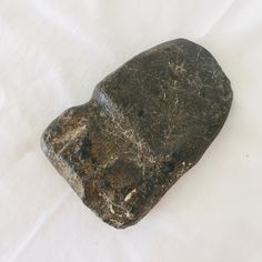 a rock sitting on top of a white sheet