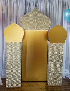 a gold and white party decoration with balloons