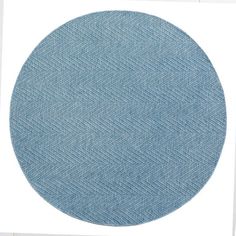 a round blue rug on top of a white wall