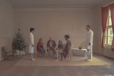 a group of people sitting around a christmas tree