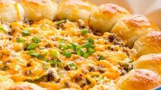 a cheesy casserole dish with green onions and sausage in it on a plate