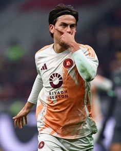 a soccer player with his hand to his mouth