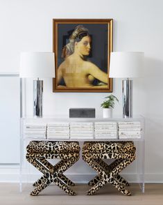 two leopard print stools sit in front of a painting on the wall behind them