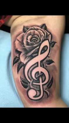 a rose and treble tattoo on the leg