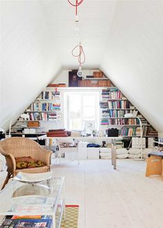 a room with white walls and lots of bookshelves in the ceiling, along with two wicker chairs