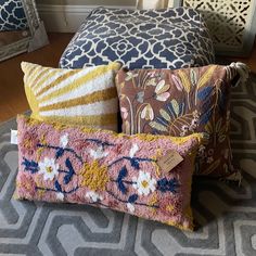 four pillows stacked on top of each other in front of a mirror and fireplace mantel