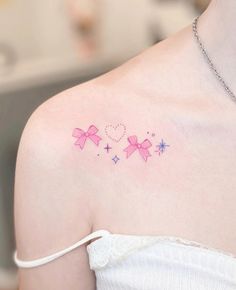 a woman's shoulder with pink bows and stars on her left shoulder, which has the word love written across it