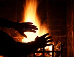 a hand reaching for something in front of a fire stock photos - image 39897