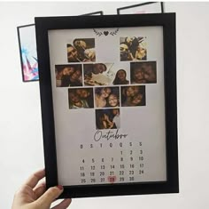 a person holding up a framed calendar with photos on it and the date is october