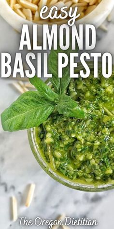 the easy almond basil pesto recipe is in a glass bowl and on top of a marble