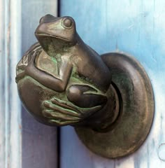 the frog is sitting on the door handle