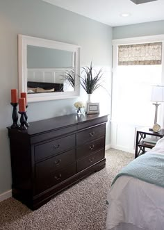 a bed room with a neatly made bed and a dresser