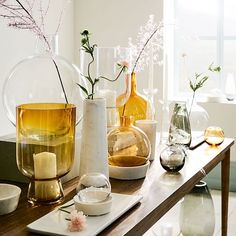 vases with flowers and candles on a table