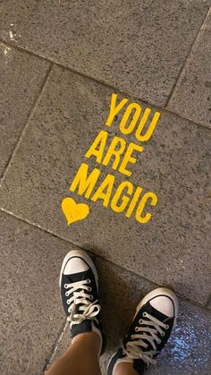 someone is standing on the sidewalk with their feet up and there is a sign that says, you are magic