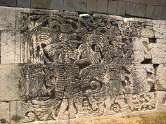 an ancient carving on the side of a stone wall with carvings and figures around it