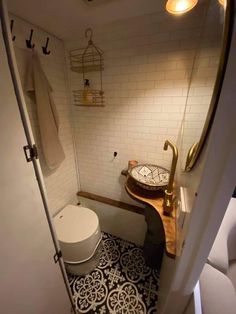 a bathroom with a toilet, sink and mirror