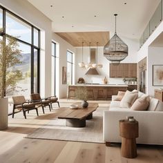 a living room filled with lots of furniture and large windows overlooking the mountains in the distance